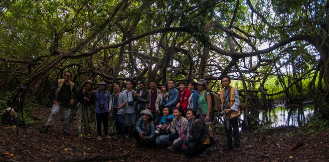 Description: Các thành viên CLB Nhiếp ảnh &amp; Du lịch chụp ảnh lưu niệm bên cây si 300 tuổi, thân mọc chằng chịt, cách khu trung tâm điều hành 16 km đường rừng. Đây là nơi xa nhất du khách được phép tham quan.