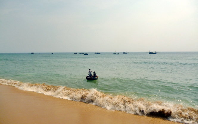 Description: Biển, tàu cá nhỏ và những người ngư dân, nhìn từ phía chân ghềnh - Ảnh: Nguyễn Thành Giang