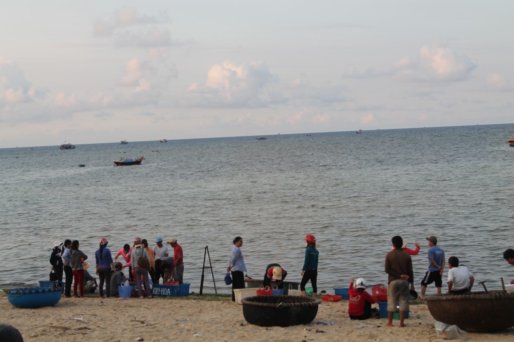Description: Người dân địa phương đang đợi thuyền đánh cá vào để thu mua hải sản. Ảnh: Khoa Trần